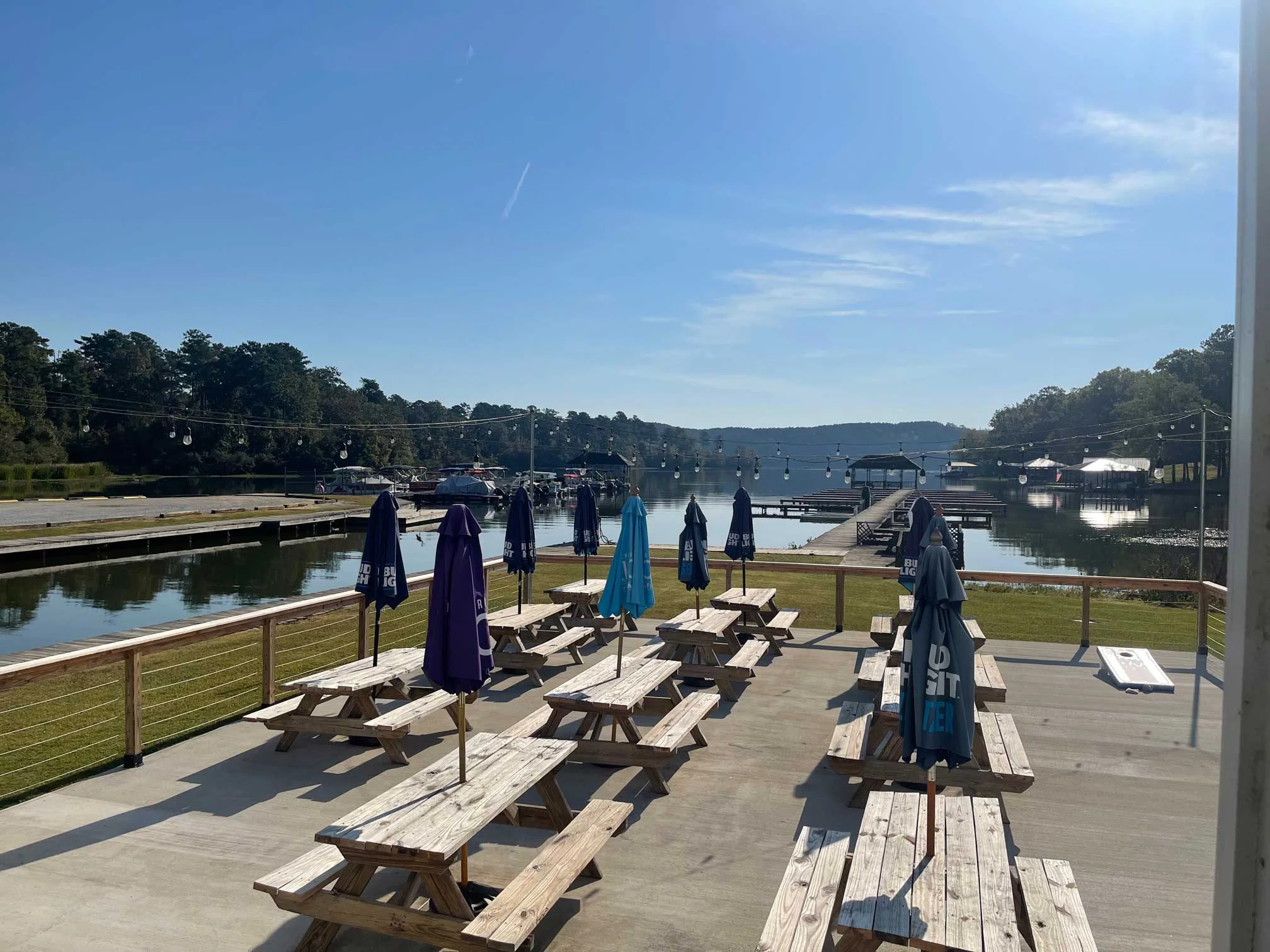 Scenic waterfront dining area with picnic tables and umbrellas