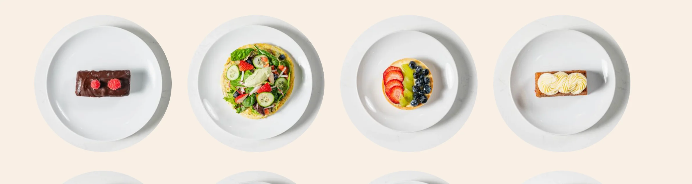 Assorted desserts including macarons and fruit tart on white plates