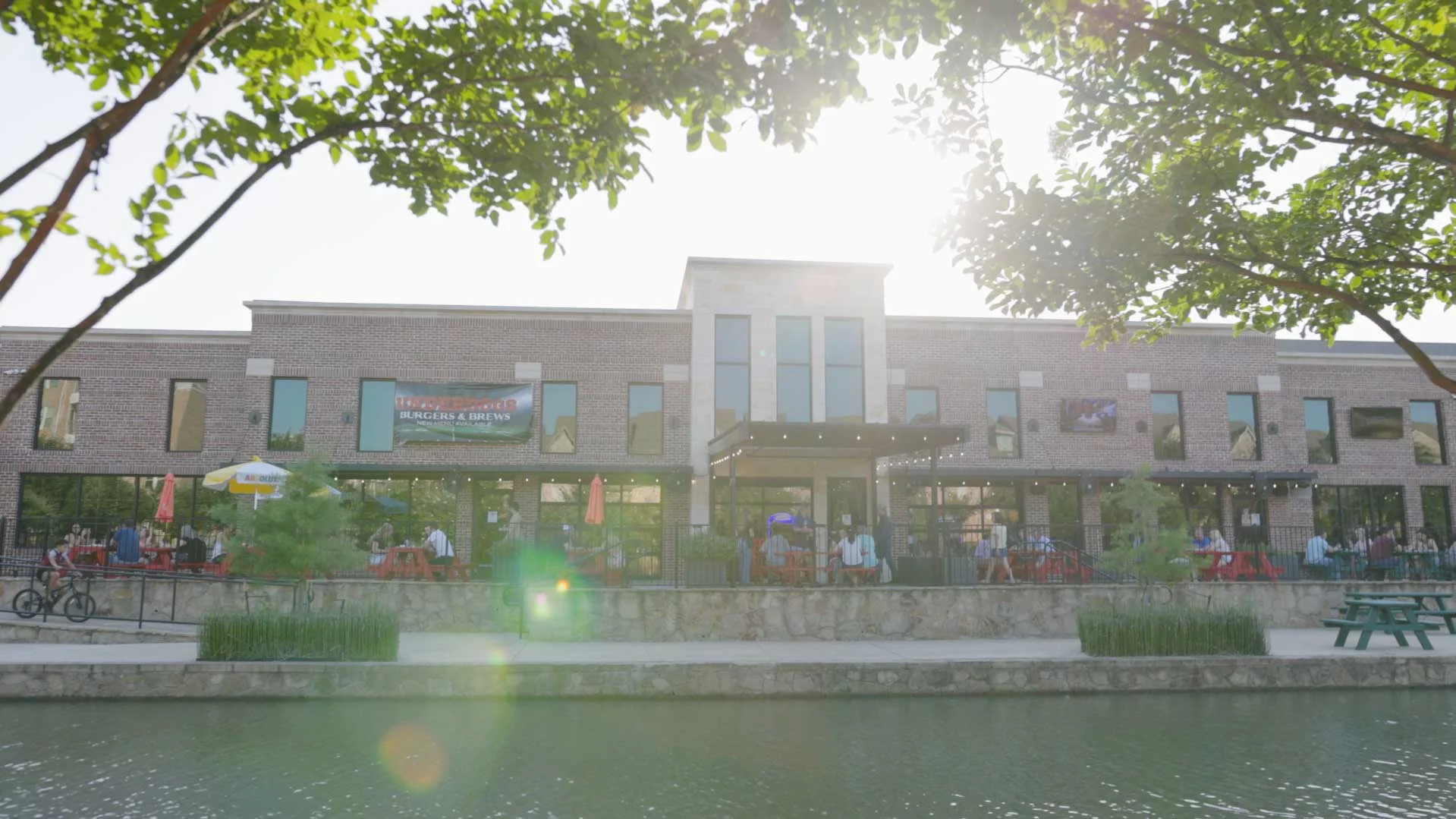 Modern restaurant exterior with outdoor seating by the water