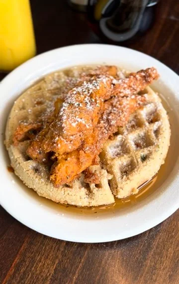 Southern chicken and waffles with powdered sugar and syrup
