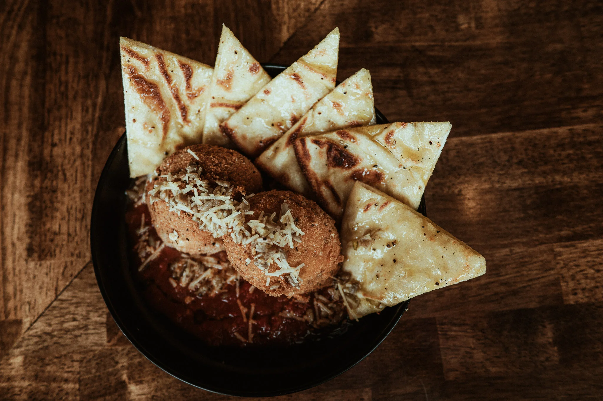 Crispy arancini served with flatbread and marinara sauce