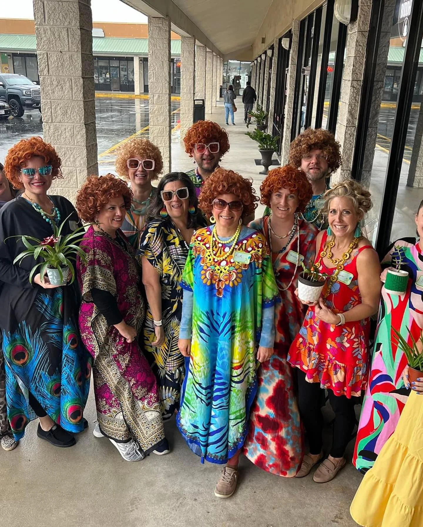 Group of friends in colorful outfits and wigs posing together