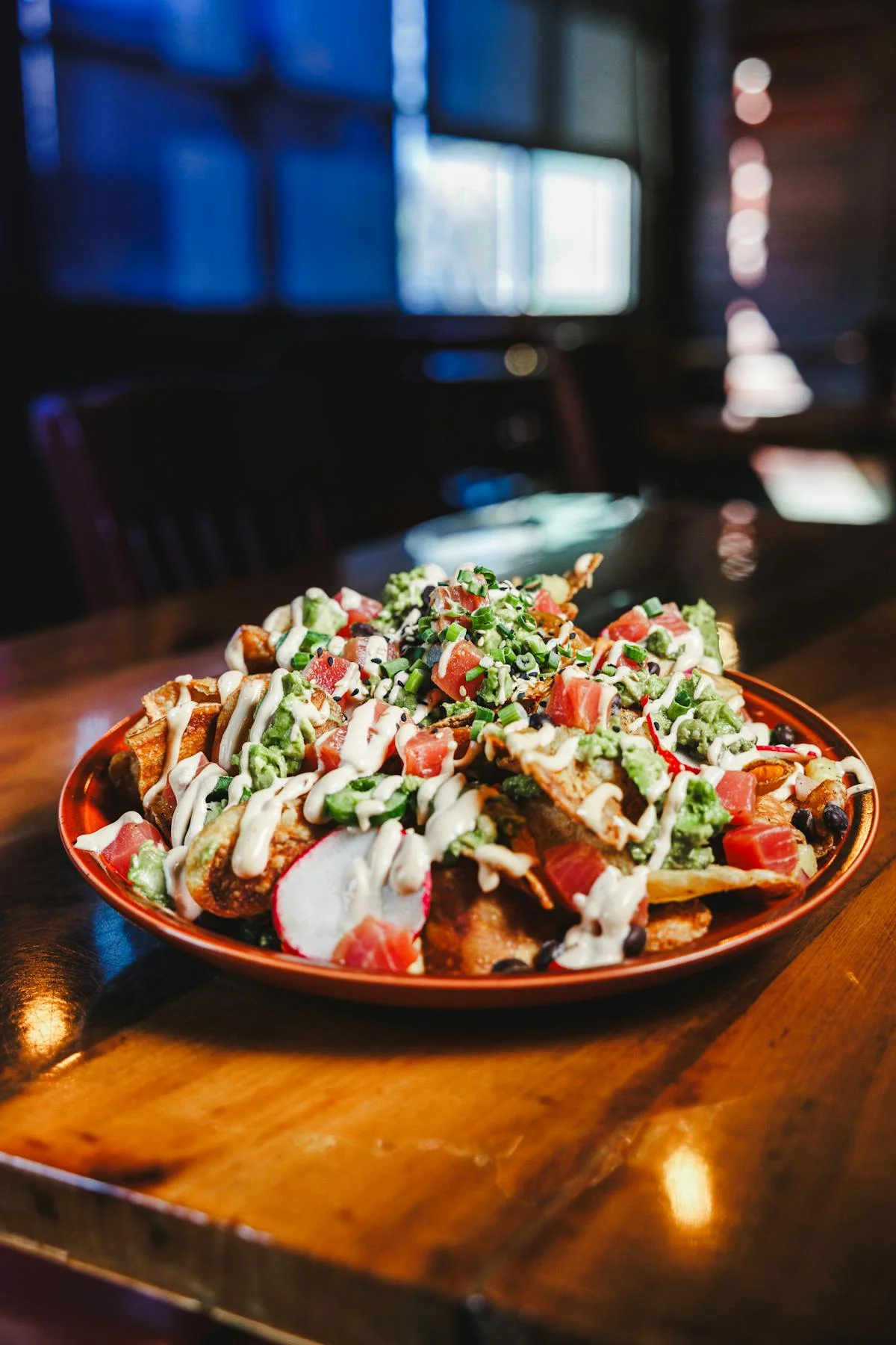 Loaded nachos topped with guacamole and fresh salsa