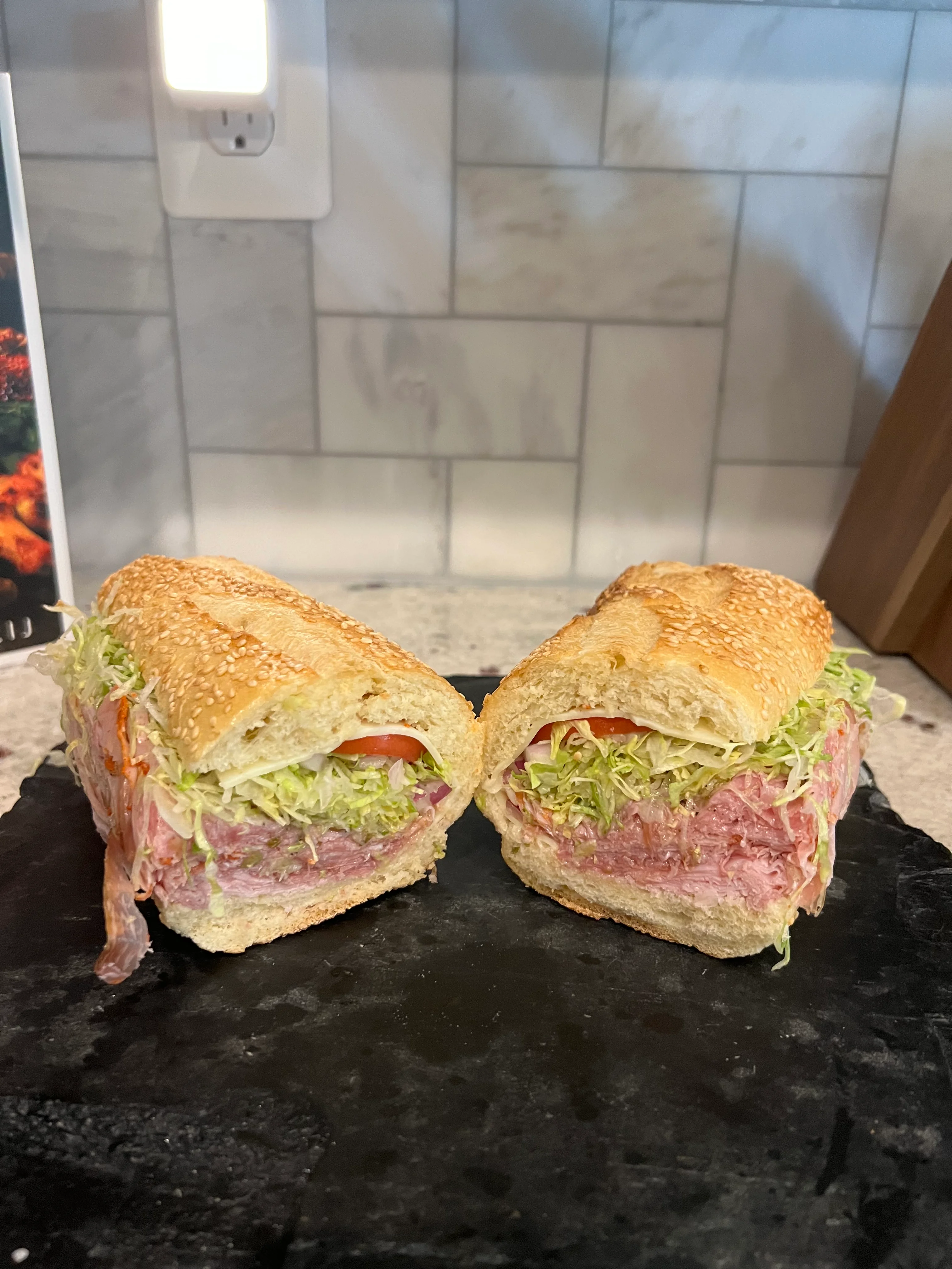 Italian sub sandwich with layers of meats and fresh vegetables
