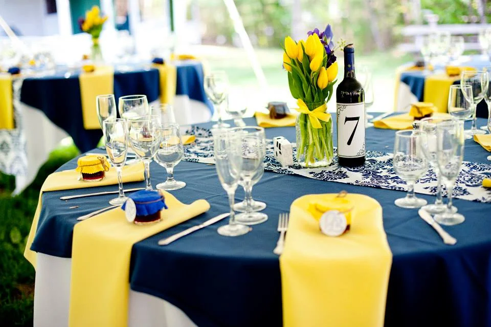 Elegant dining setup with yellow tulips and wine bottle