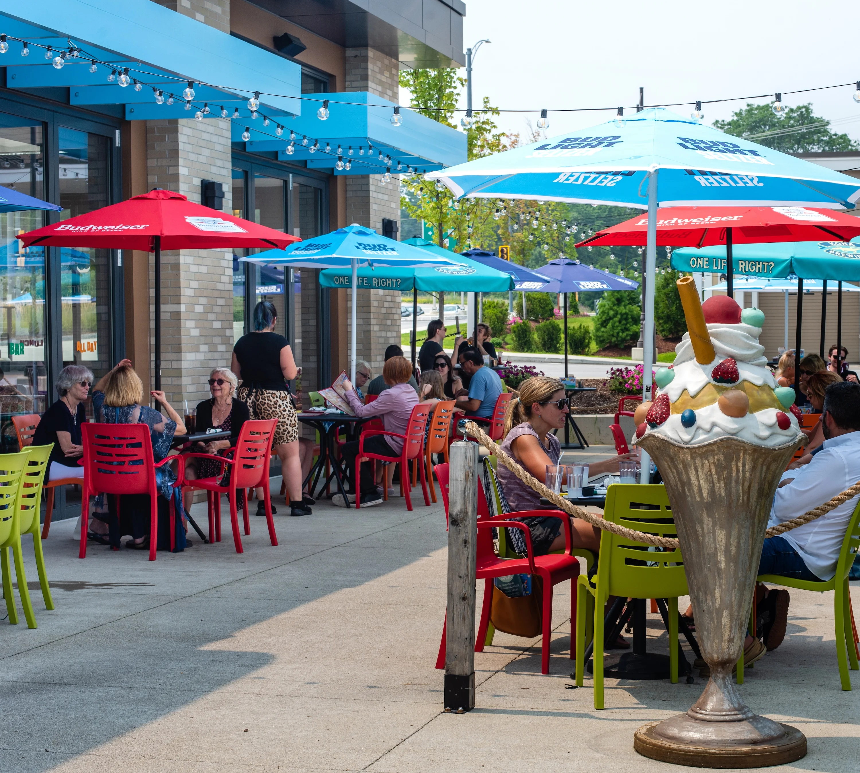 Outdoor dining area with colorful umbrellas and patrons enjoying their meals