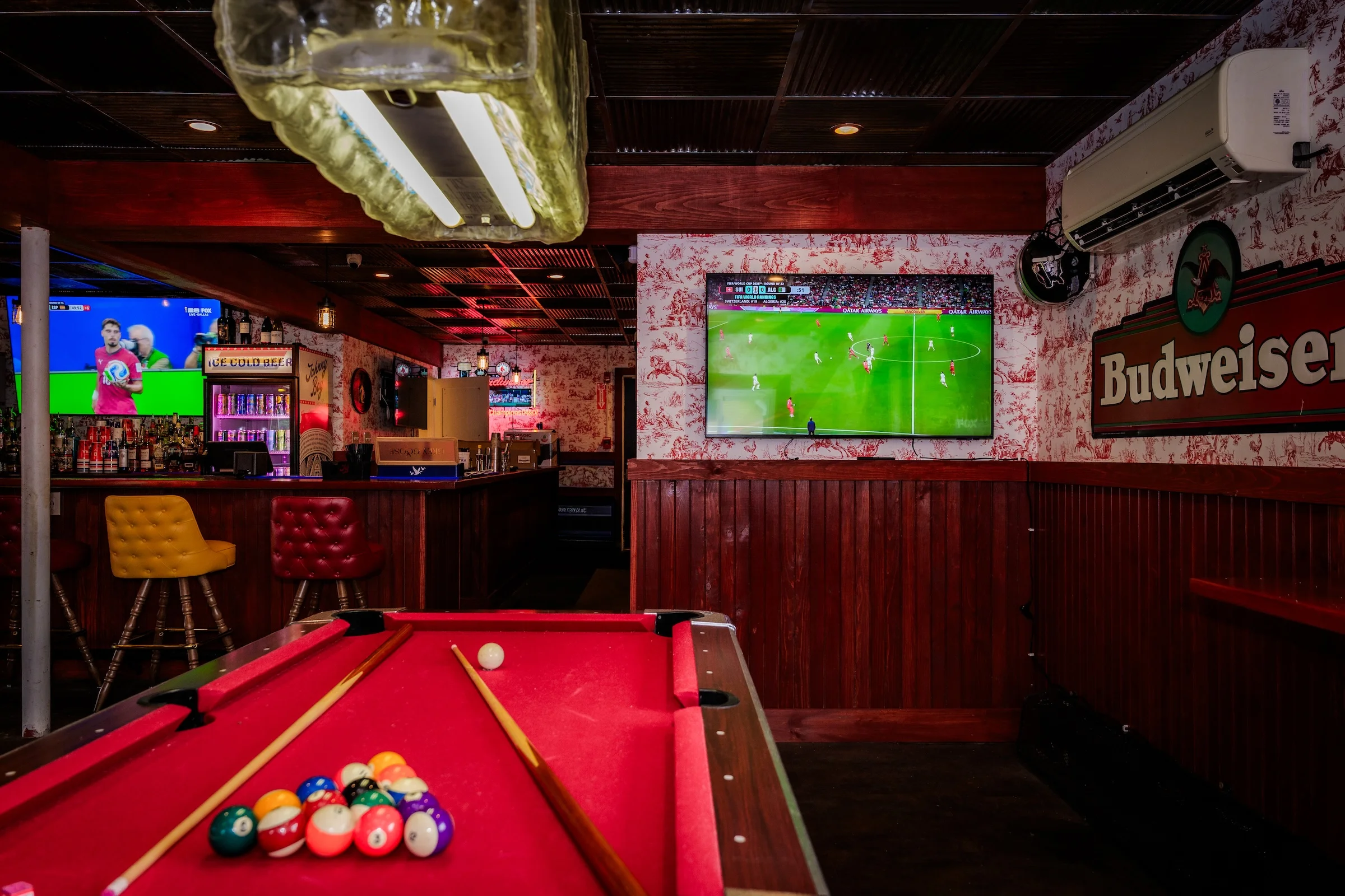 Cozy bar interior with pool table and sports on TV