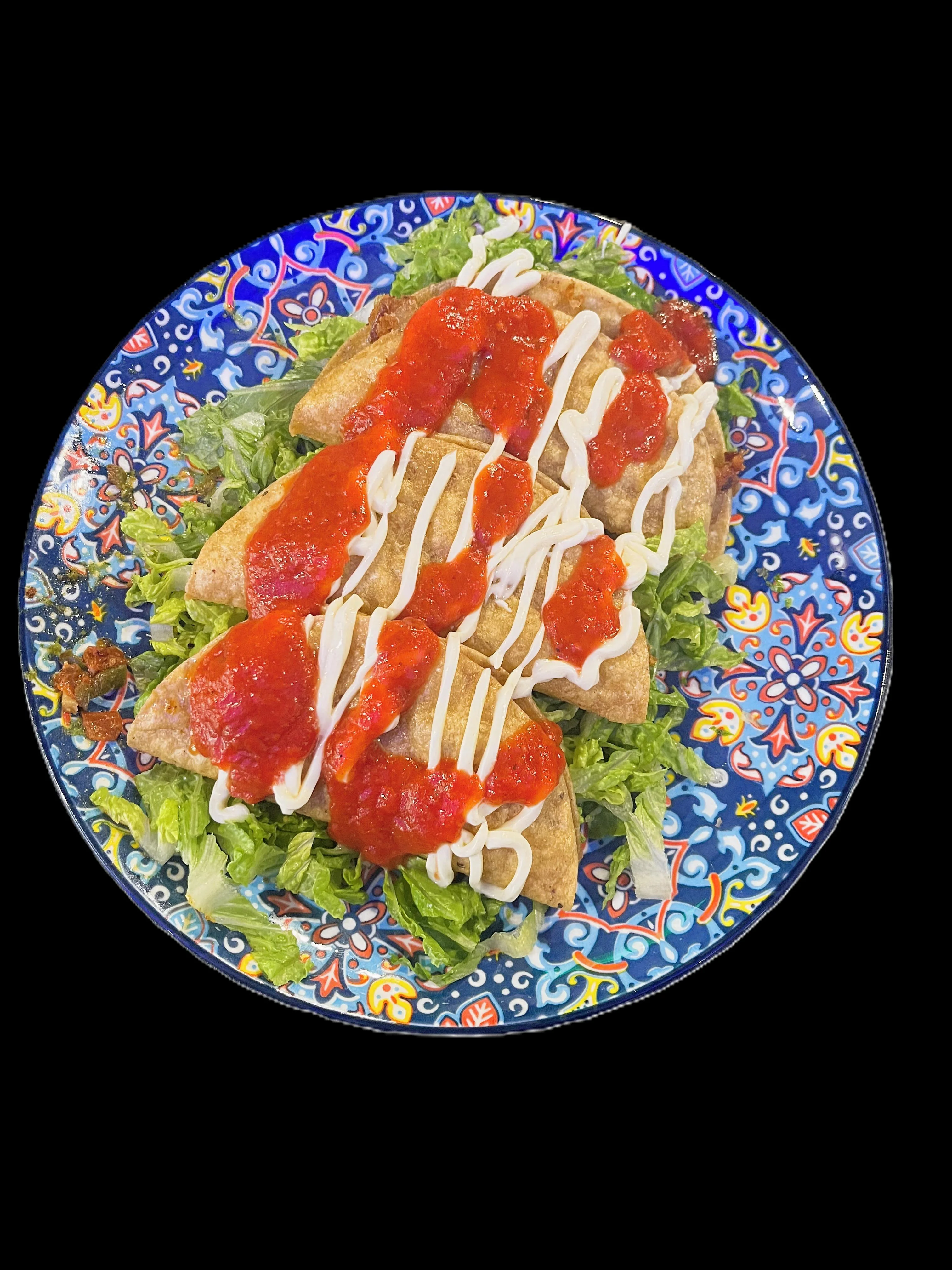 Crispy Mexican flautas topped with salsa and crema