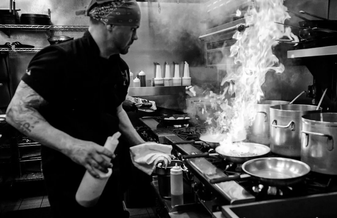Chef Anton Testino cooking over stove top flames