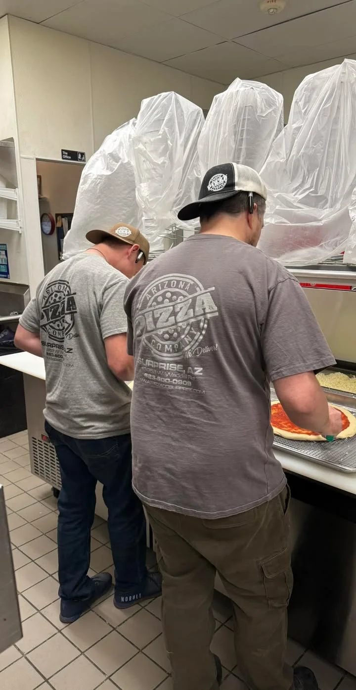 Pizza preparation in a bustling kitchen
