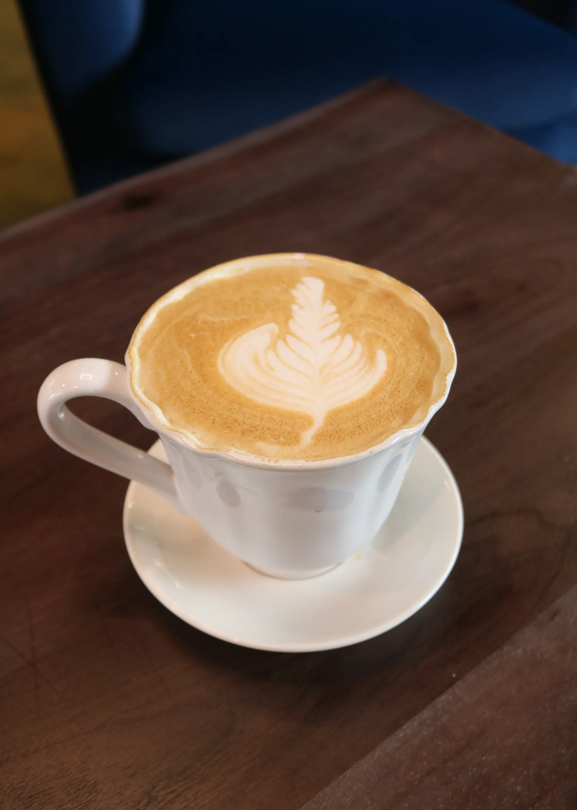 Artisan latte with leaf design in a white cup