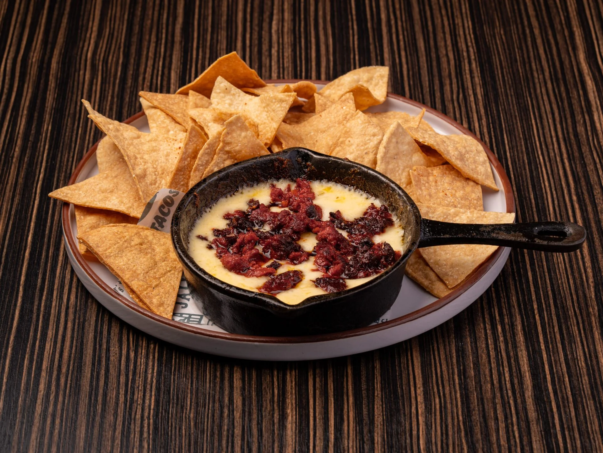 Cheesy queso fundido with chicharrón served with tortilla chips