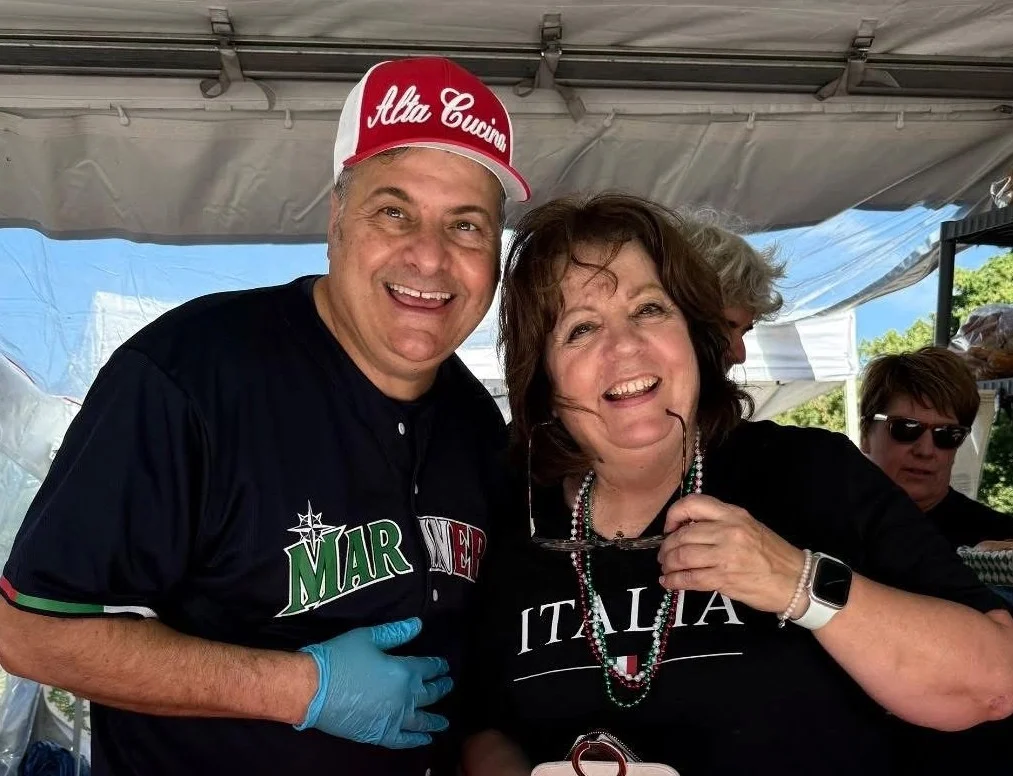Two smiling people at a food festival booth