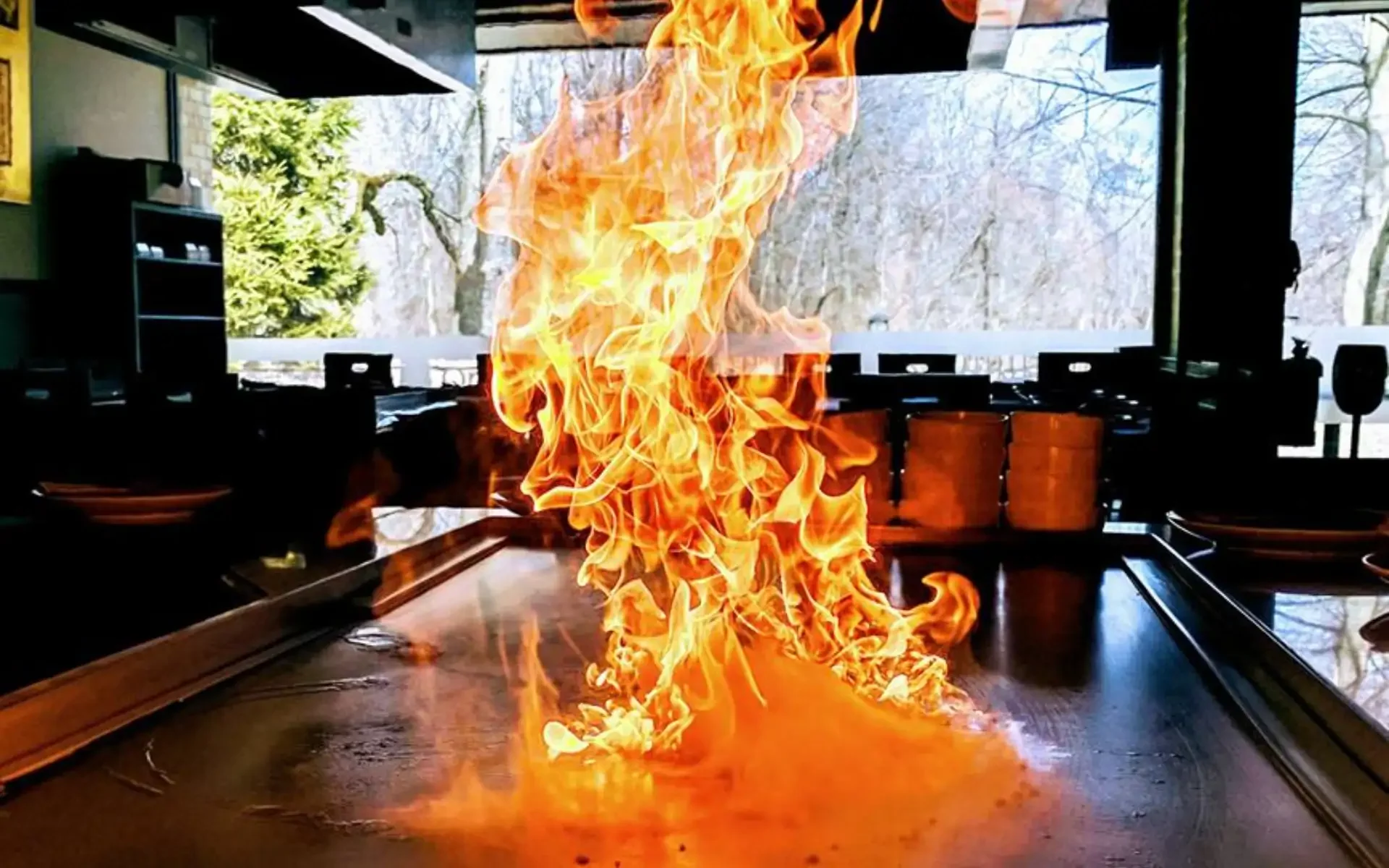 Flaming hibachi grill with vibrant flames in a restaurant setting