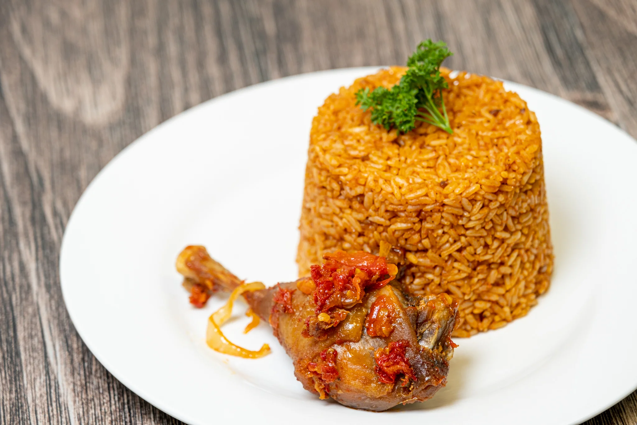 Nigerian jollof rice with chicken served on a white plate