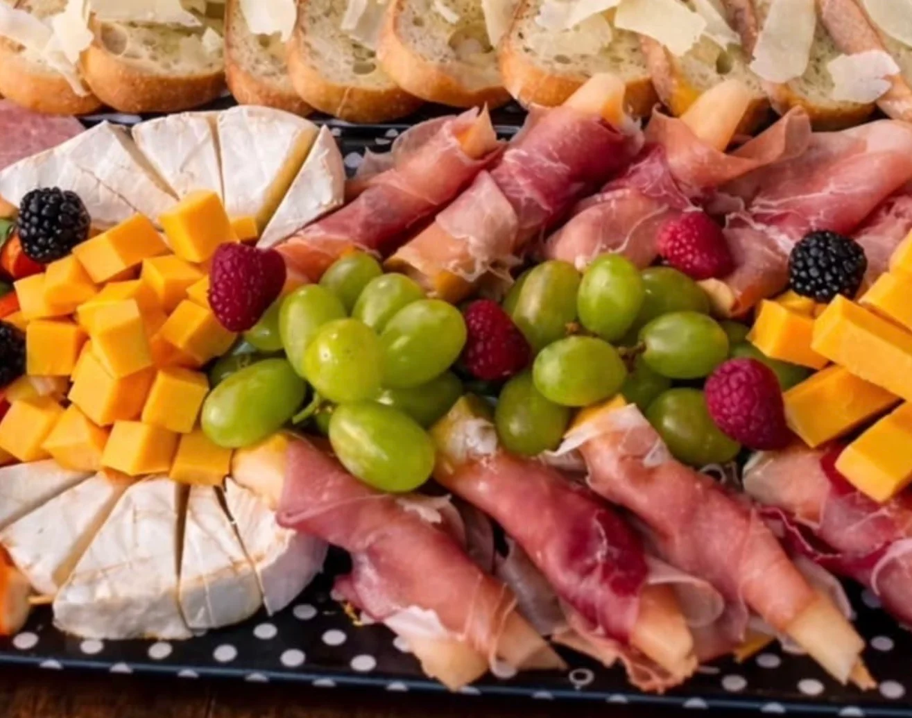 Charcuterie board with assorted meats, cheeses, and wine