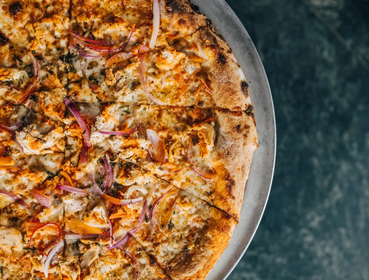 Spicy chicken pizza with red onions