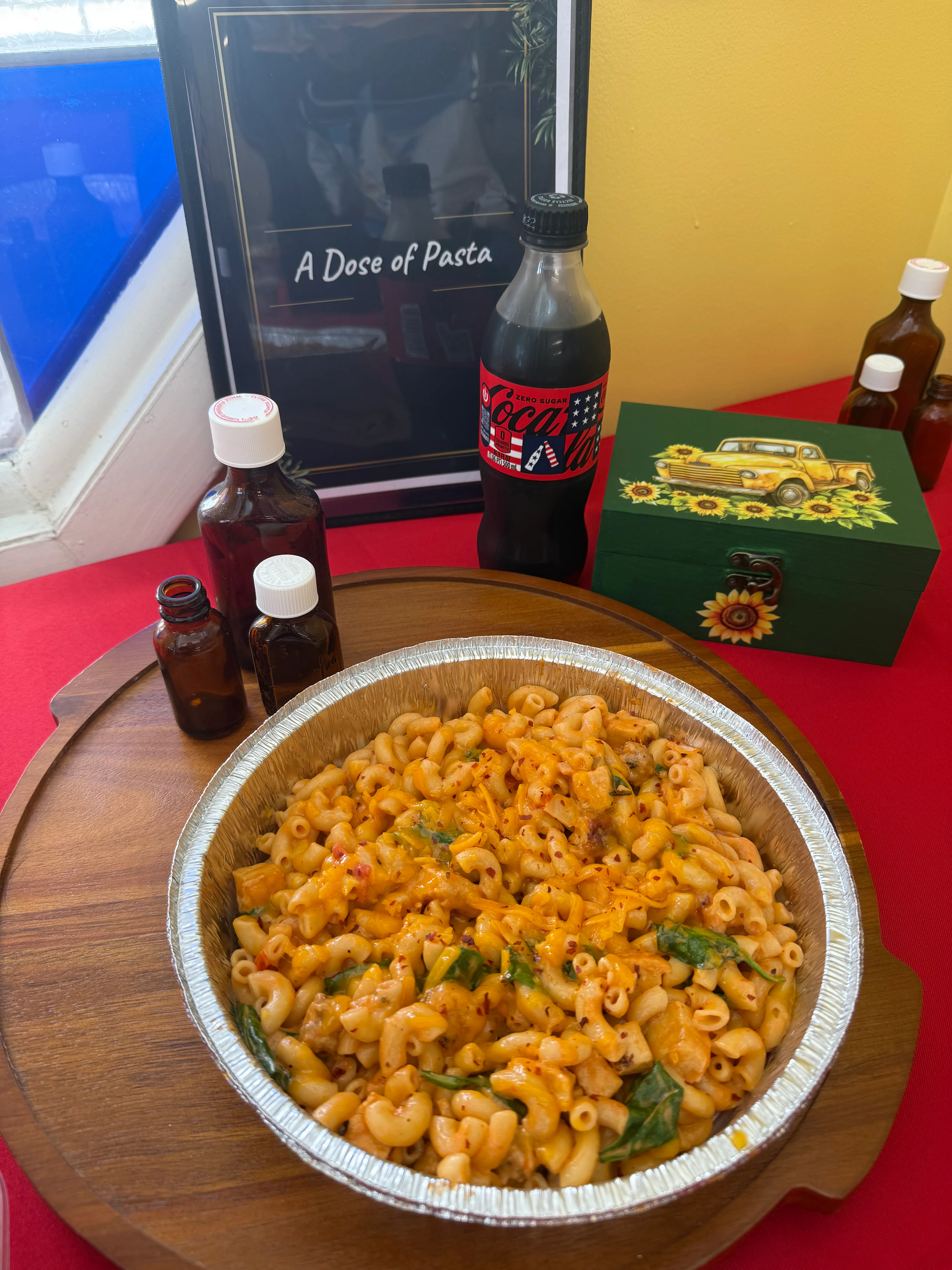 Baked macaroni and cheese with greens in a foil tray