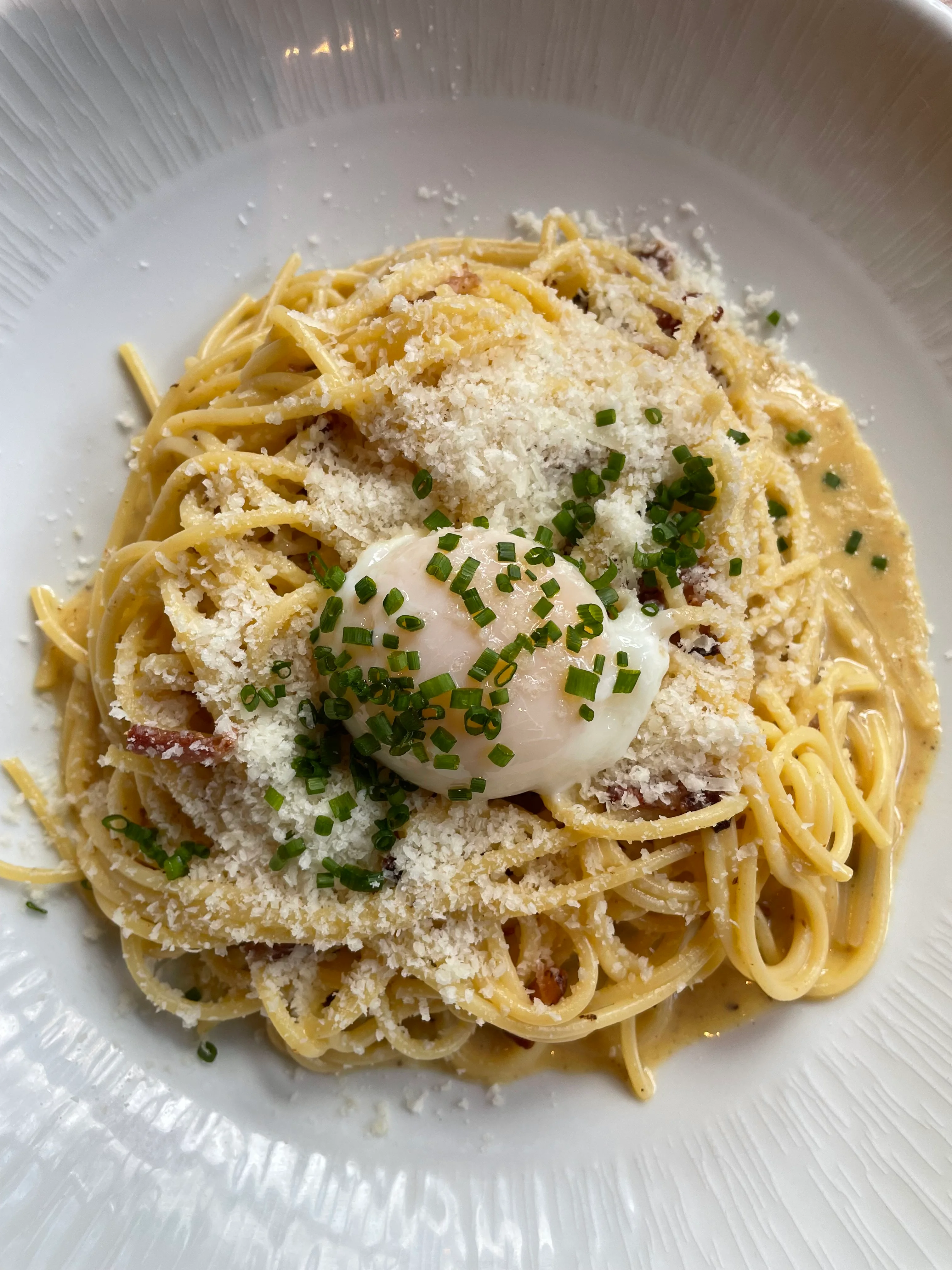 Creamy Italian carbonara pasta with poached egg