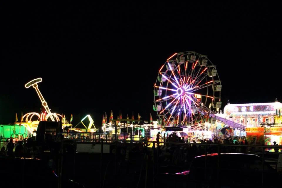 Vibrant carnival scene with illuminated rides at night