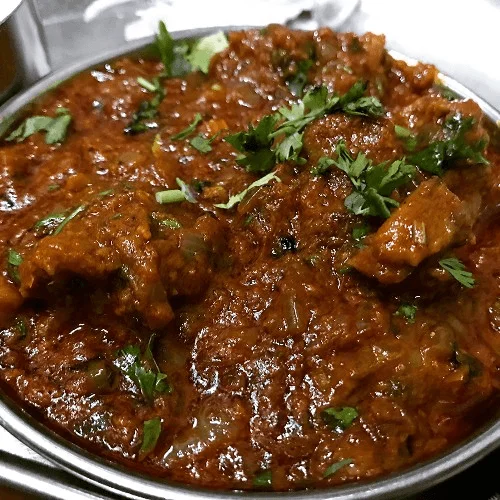 Egg plant masala in a traditional bronze serving bowl.