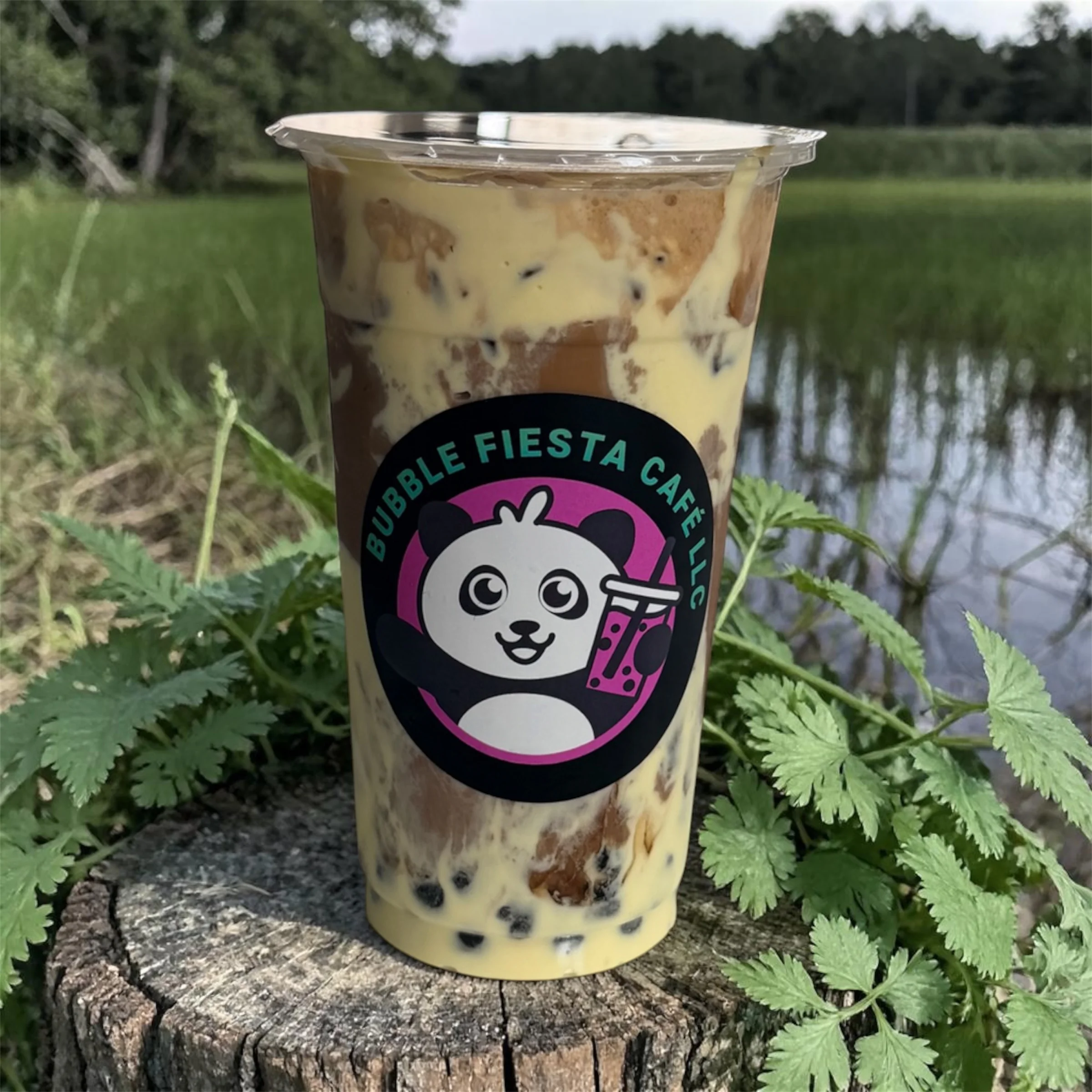 Iced bubble tea with creamy layers in a scenic outdoor setting