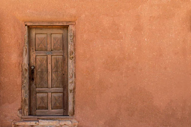 Rustic wooden door on a textured adobe wall