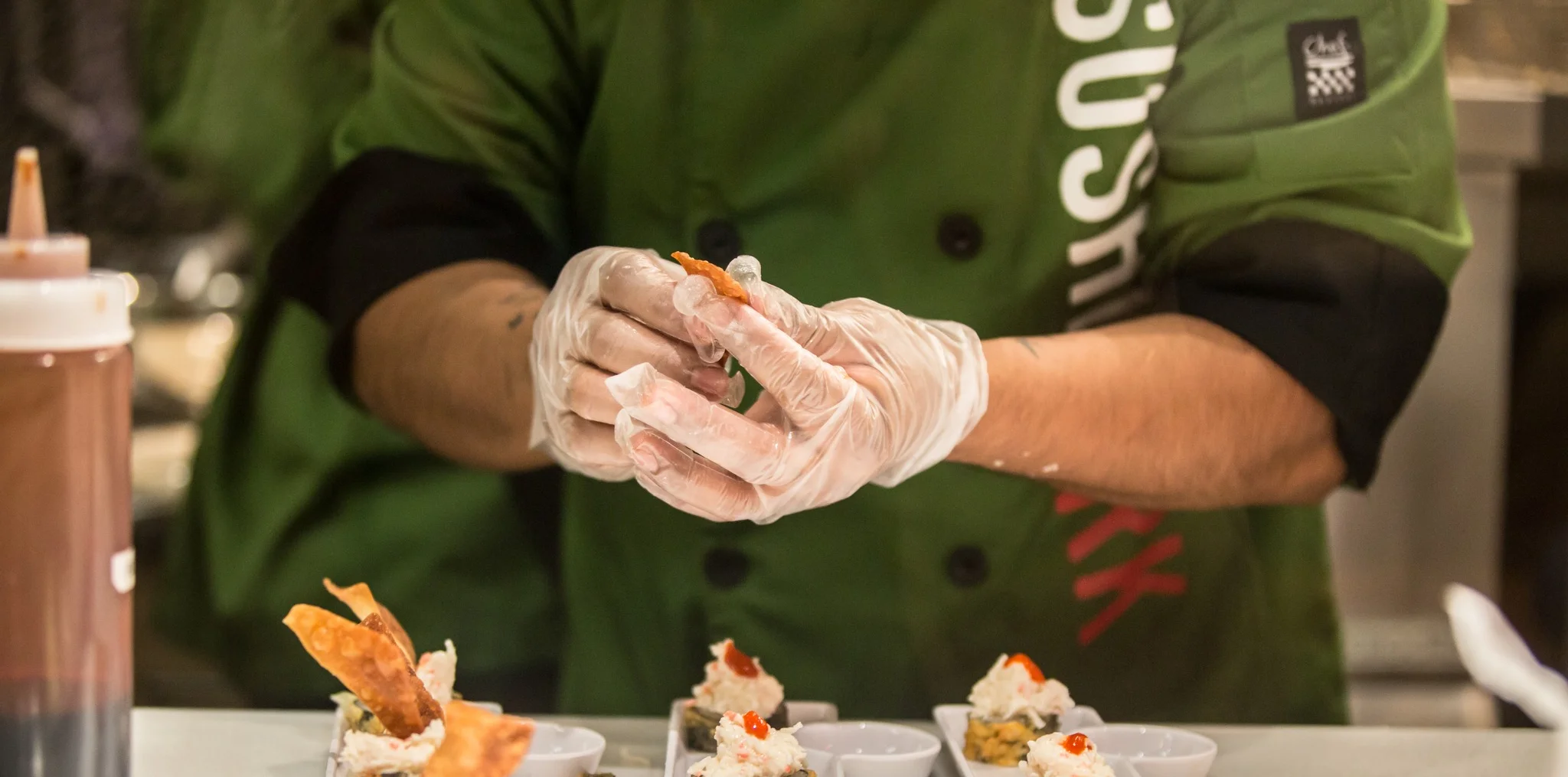 Chef preparing sushi rolls with precision in a vibrant kitchen