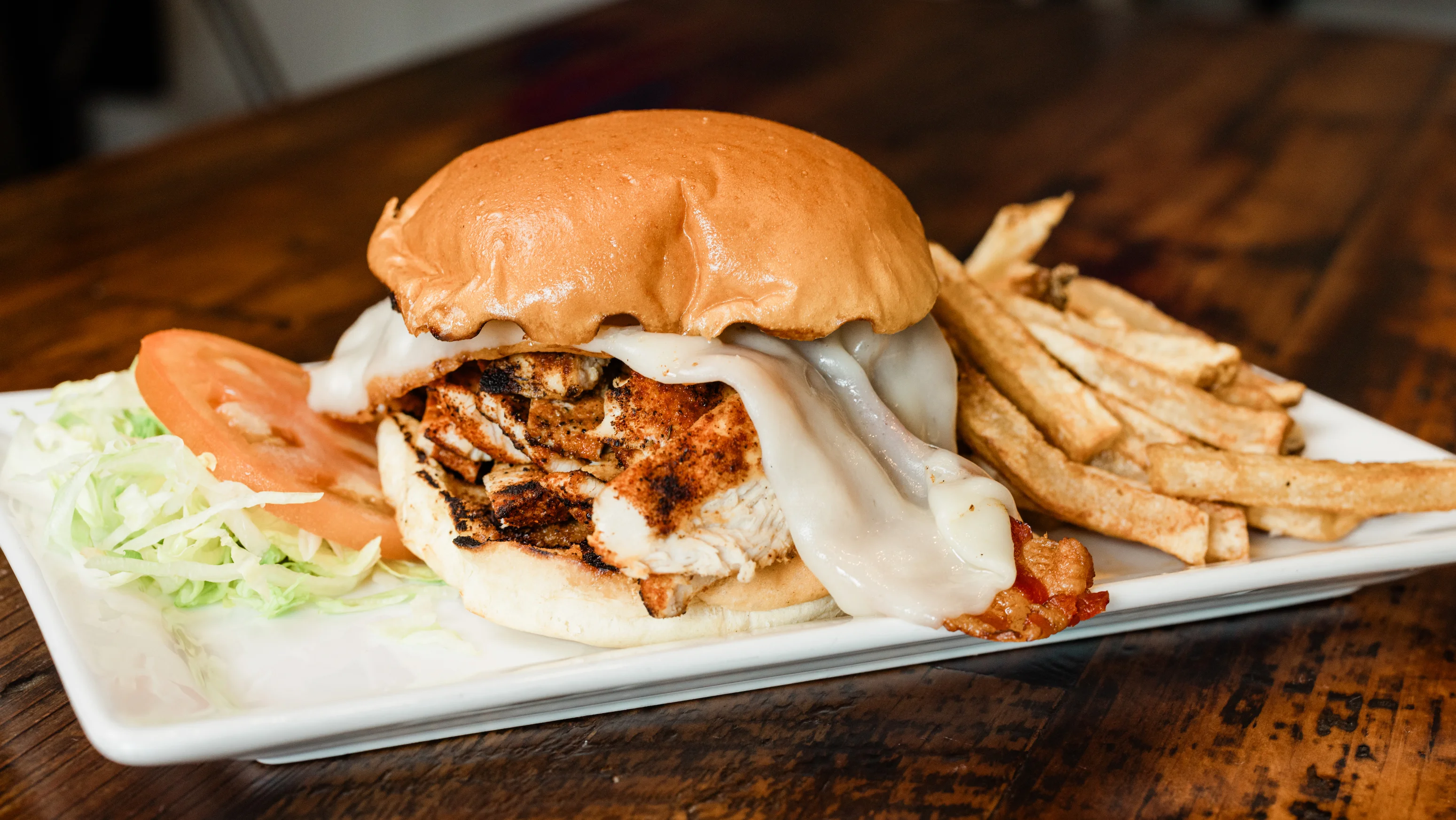 Grilled chicken sandwich with cheese and fries