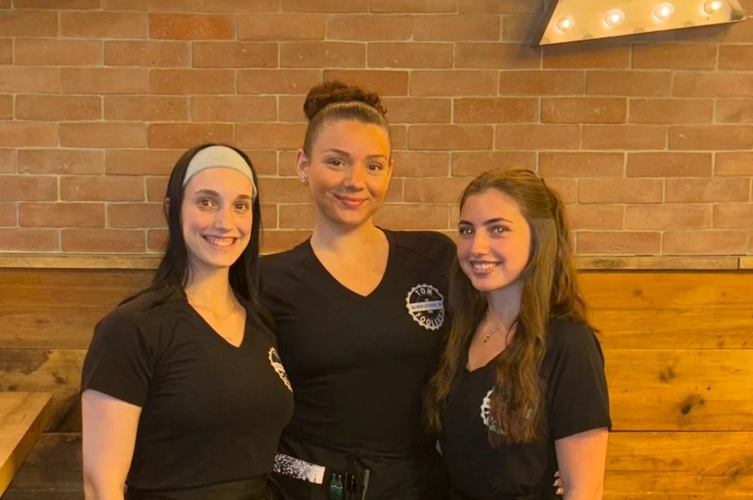 Friendly restaurant staff posing together in a cozy dining area