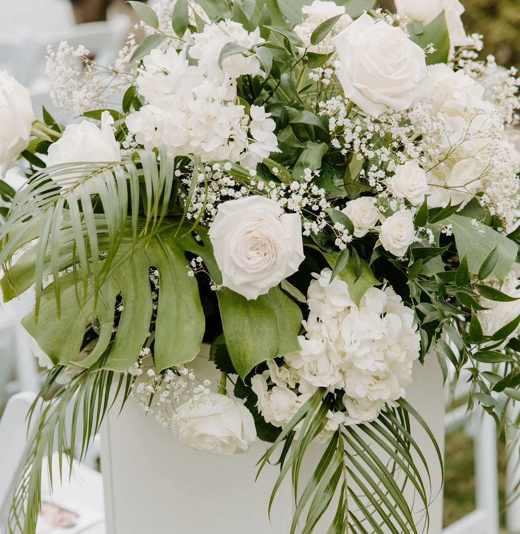 Elegant floral arrangement with white roses and greenery