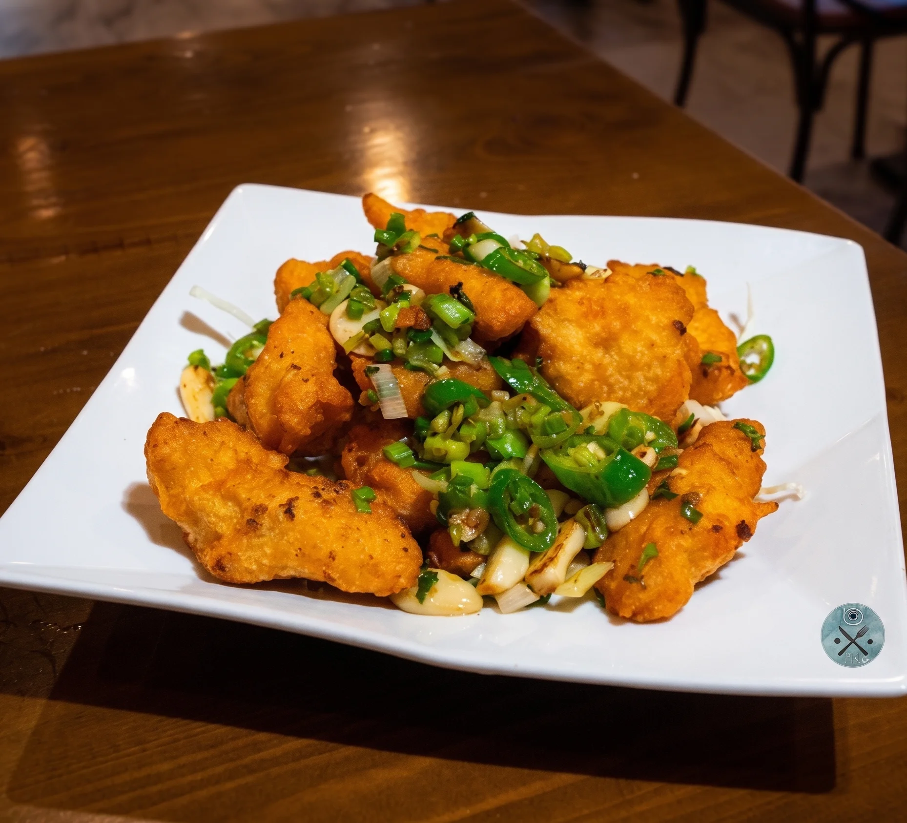 Golden-brown dumplings served with dipping sauce and garnished with flowers.