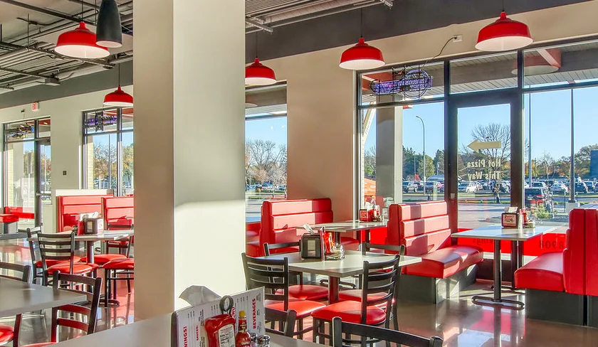 Modern restaurant interior with red booths and bright lighting