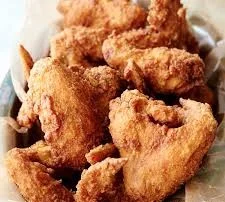 A serving of golden-brown fried chicken wings, arranged neatly on a platter.