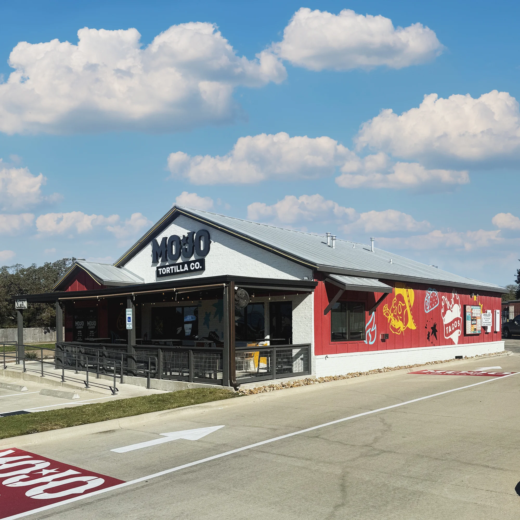 Exterior view of Mojo Tortilla Co. restaurant with vibrant murals