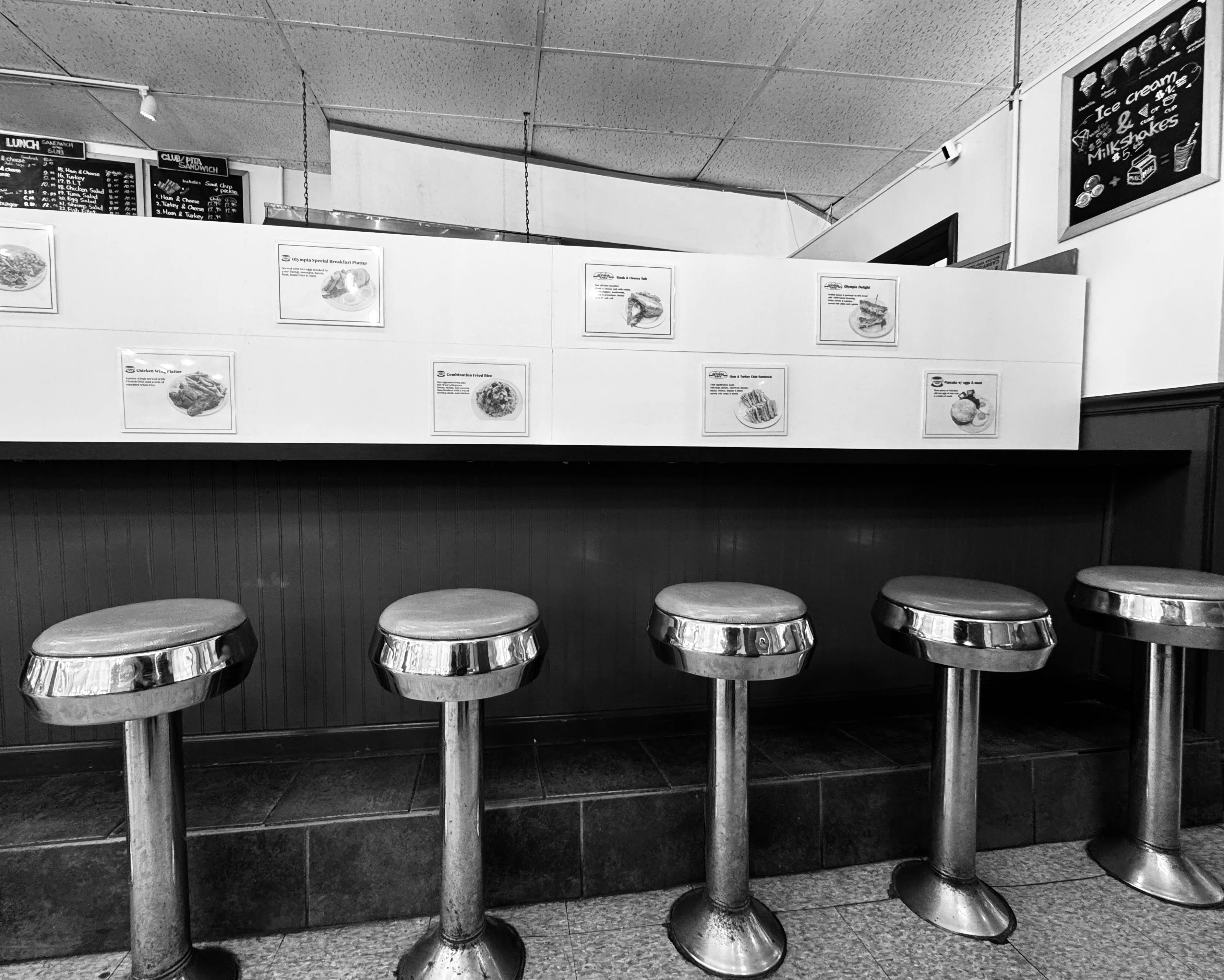 Cozy diner interior with chrome stools and menu displays