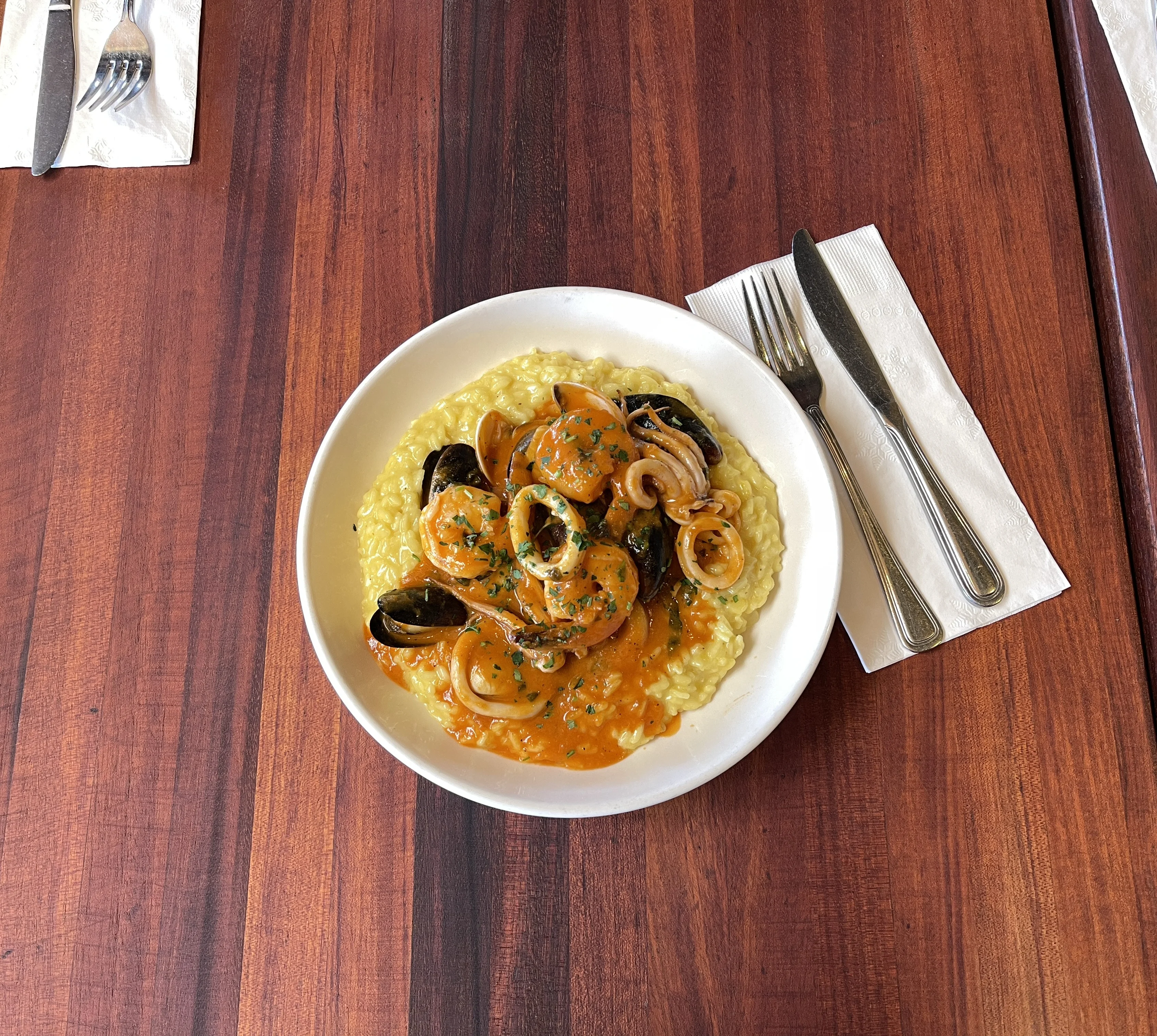 Italian seafood risotto with mussels and calamari on a restaurant table