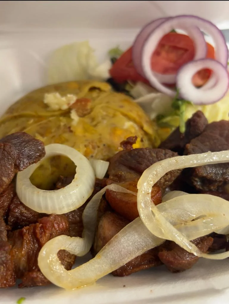 Delicious Mexican carne asada with grilled onions and sides