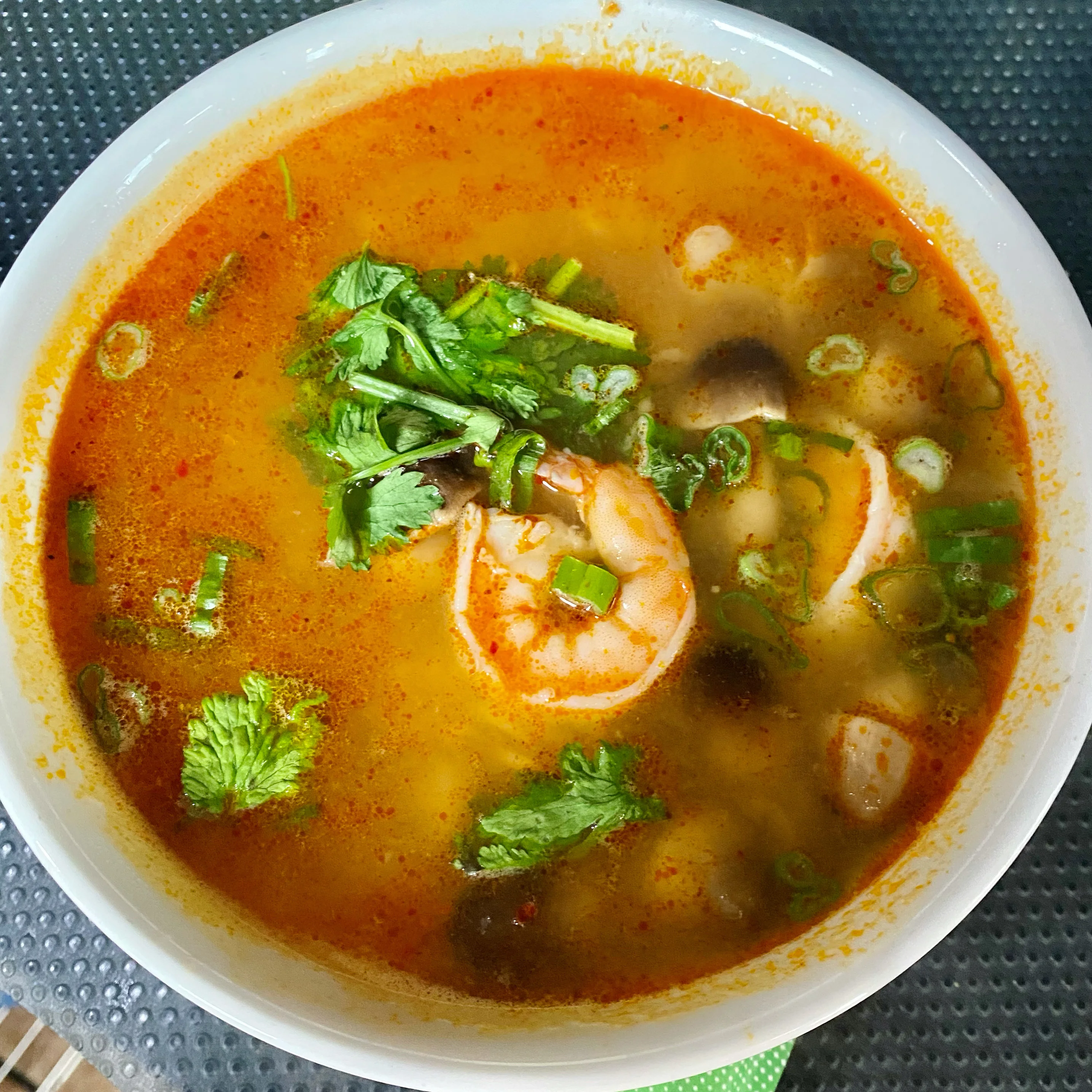 Spicy Thai tom yum soup with shrimp and fresh herbs