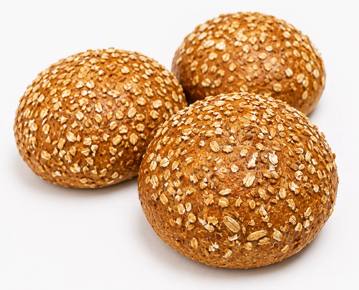 Three round, sesame-topped whole grain rolls.