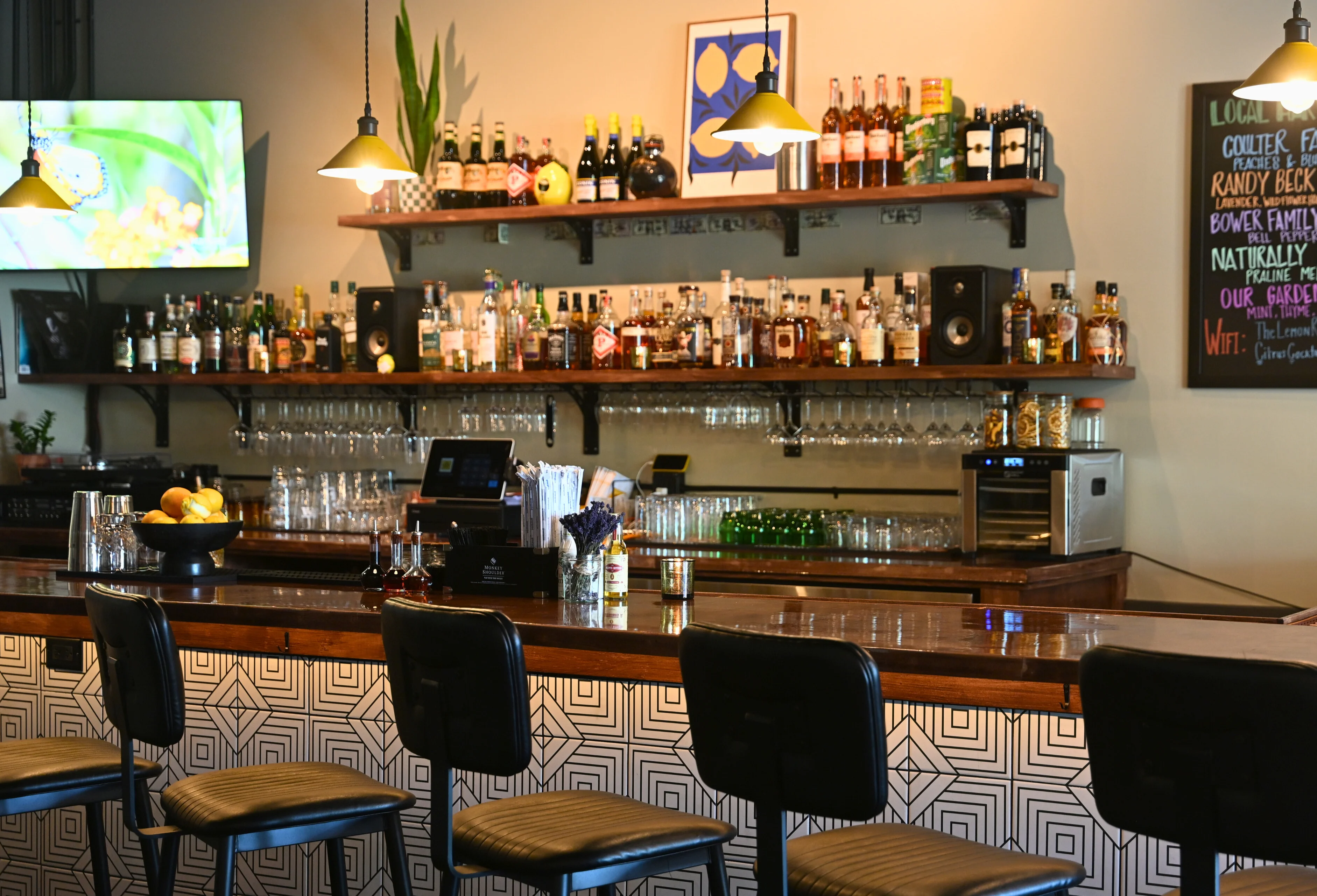 Modern bar interior with shelves of spirits and stylish seating