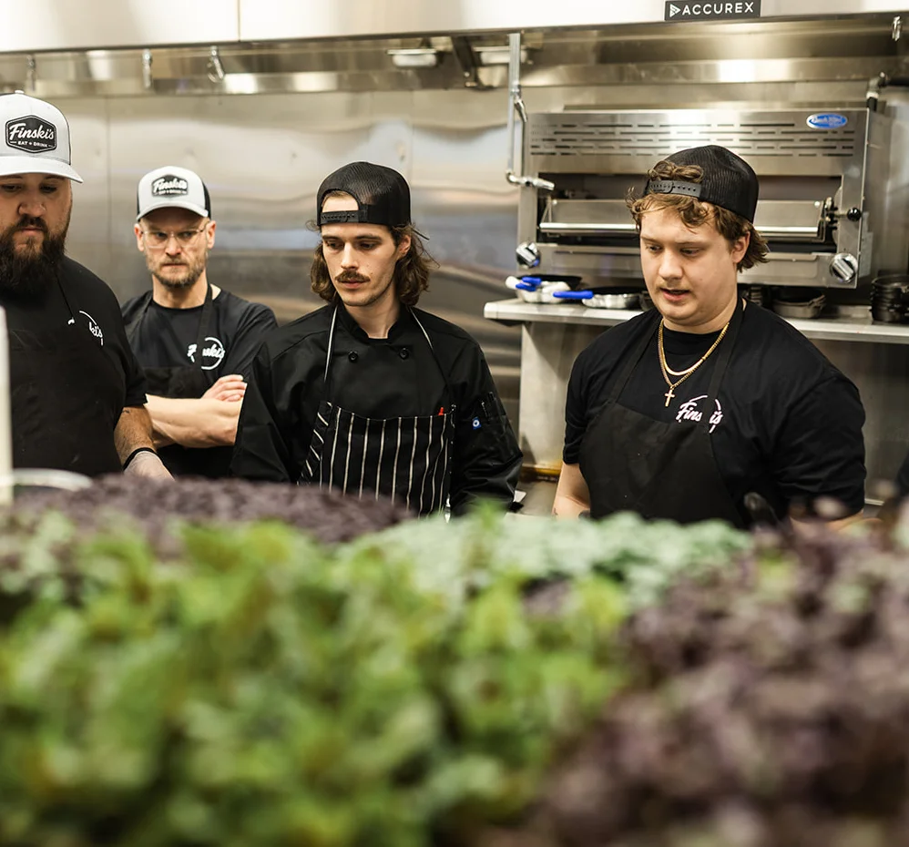 Culinary team focused on fresh herbs in a modern kitchen