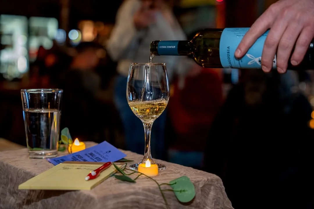 Pouring white wine into a glass at a cozy restaurant setting