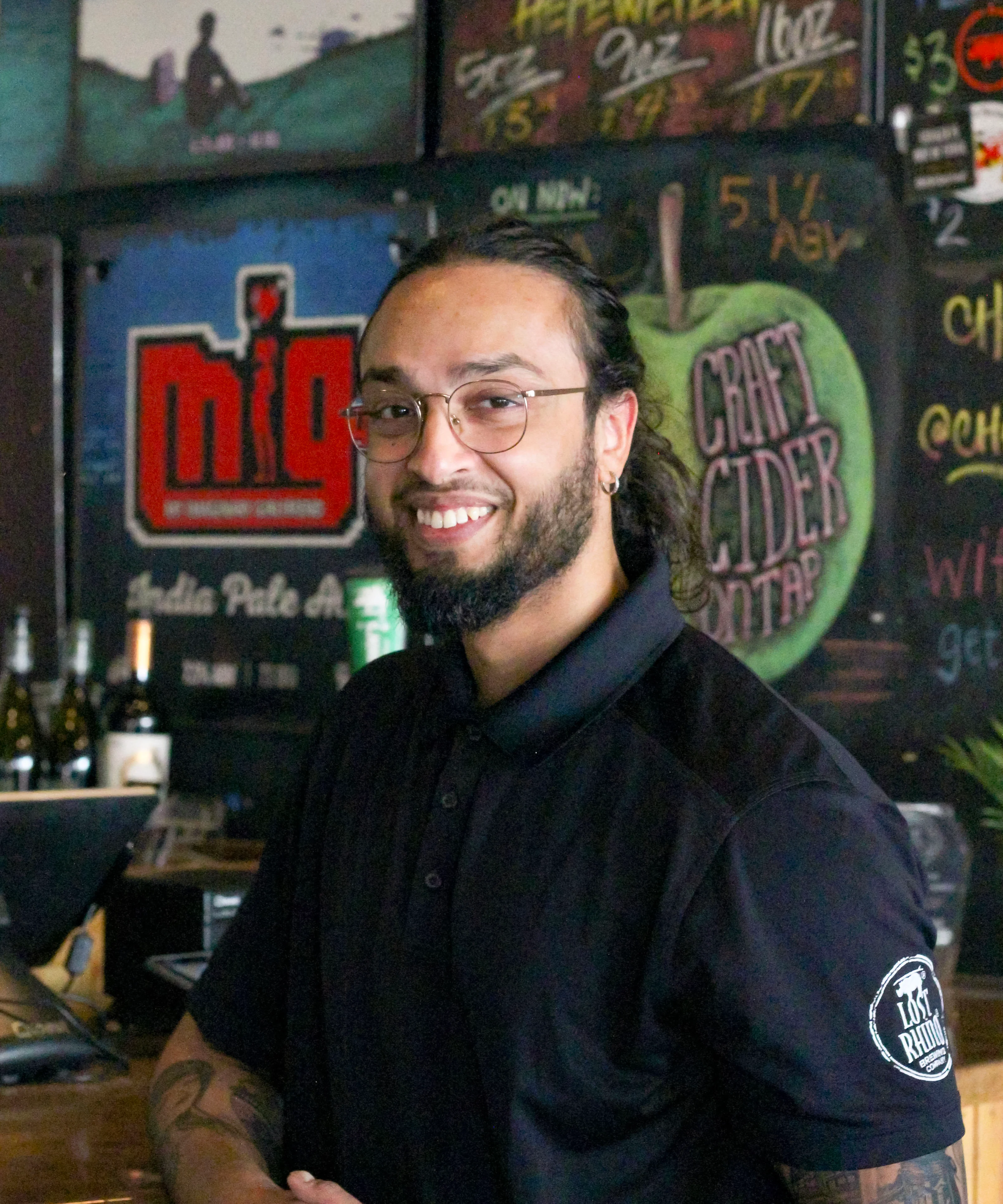 Bartender smiling at a vibrant bar with craft beer selections