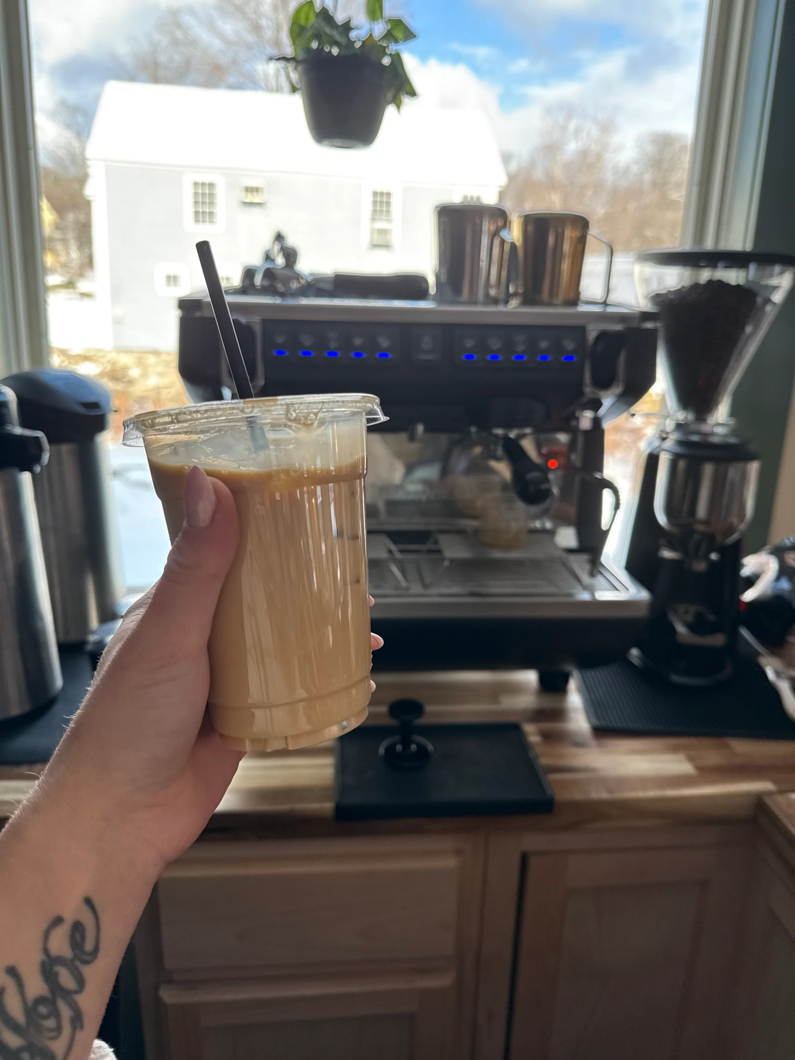Iced coffee drink in front of an espresso machine