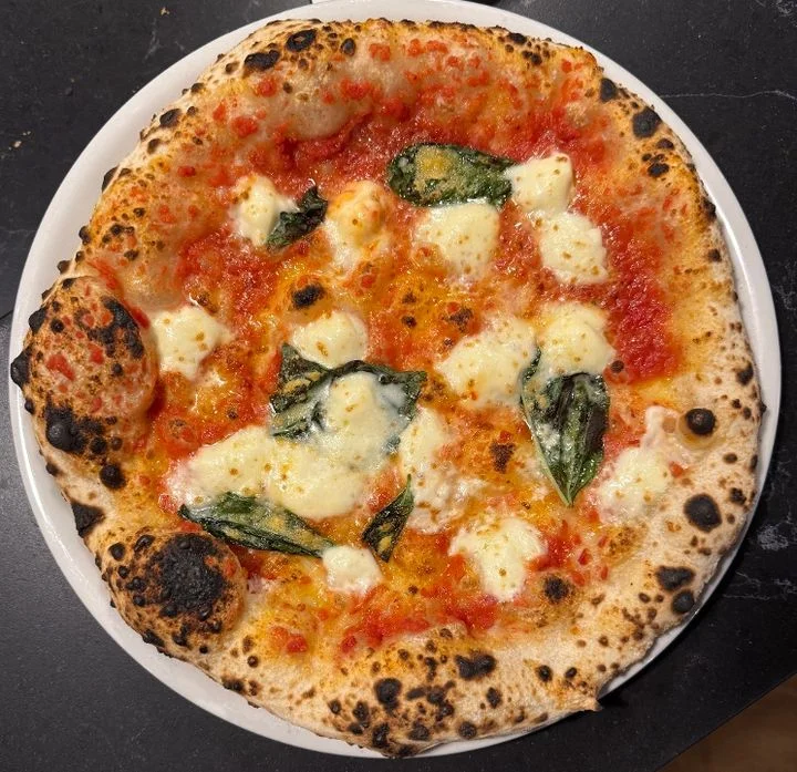 Freshly baked pizza topped with arugula in a cozy restaurant setting