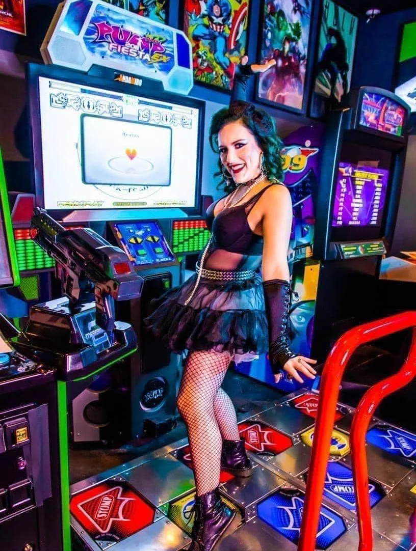 Woman in a playful outfit at an arcade game