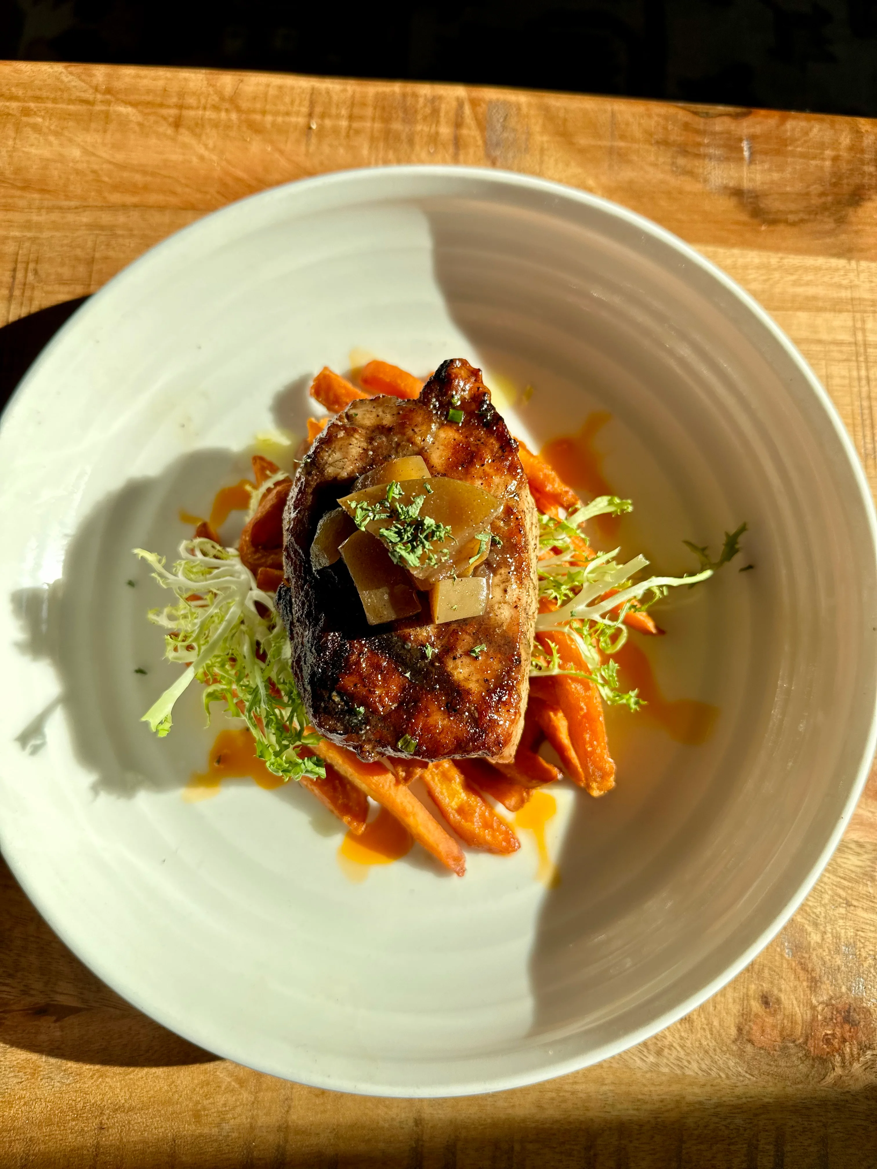 Grilled pork chop with sweet potato and greens