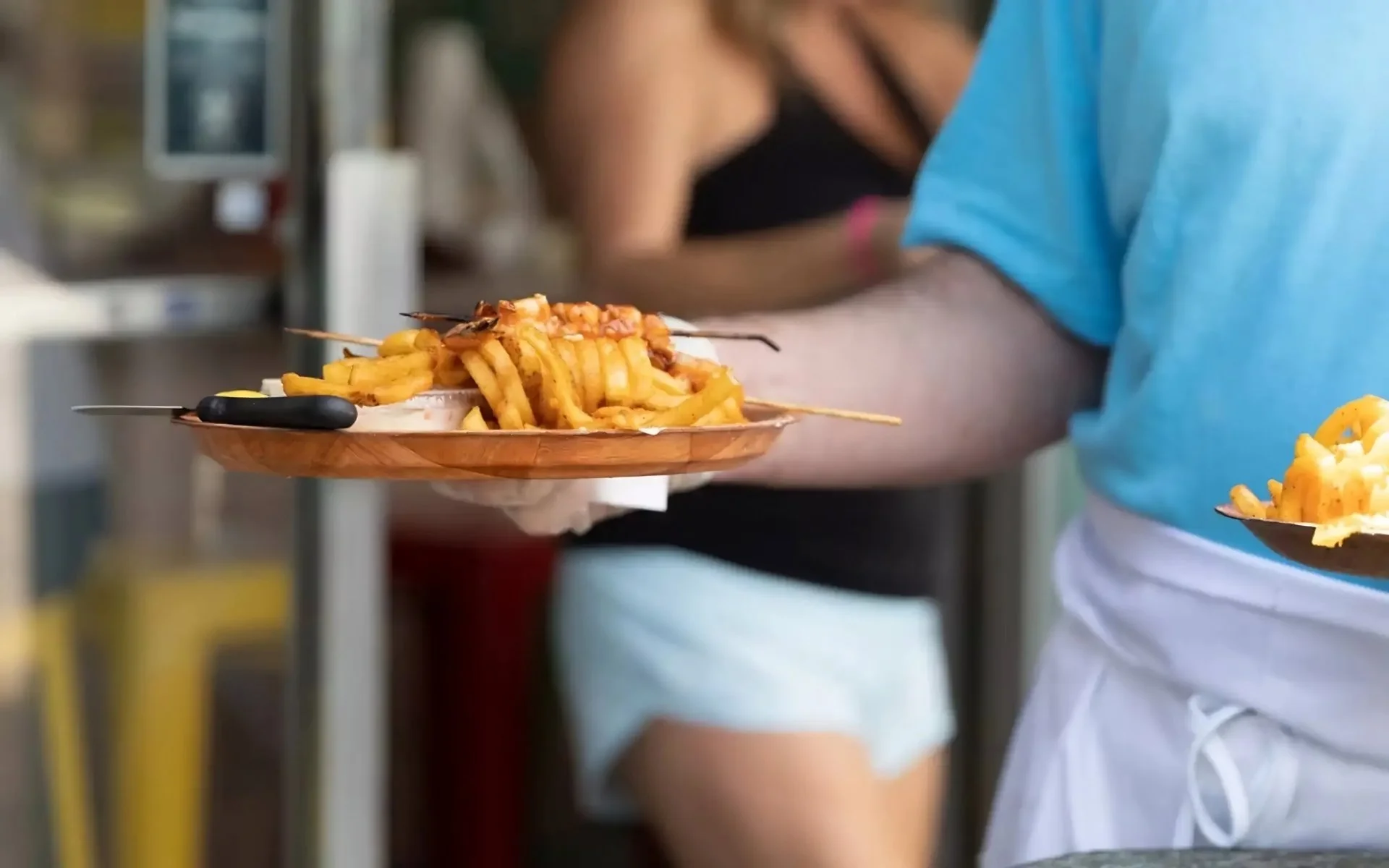 Waiter serving fries on plate