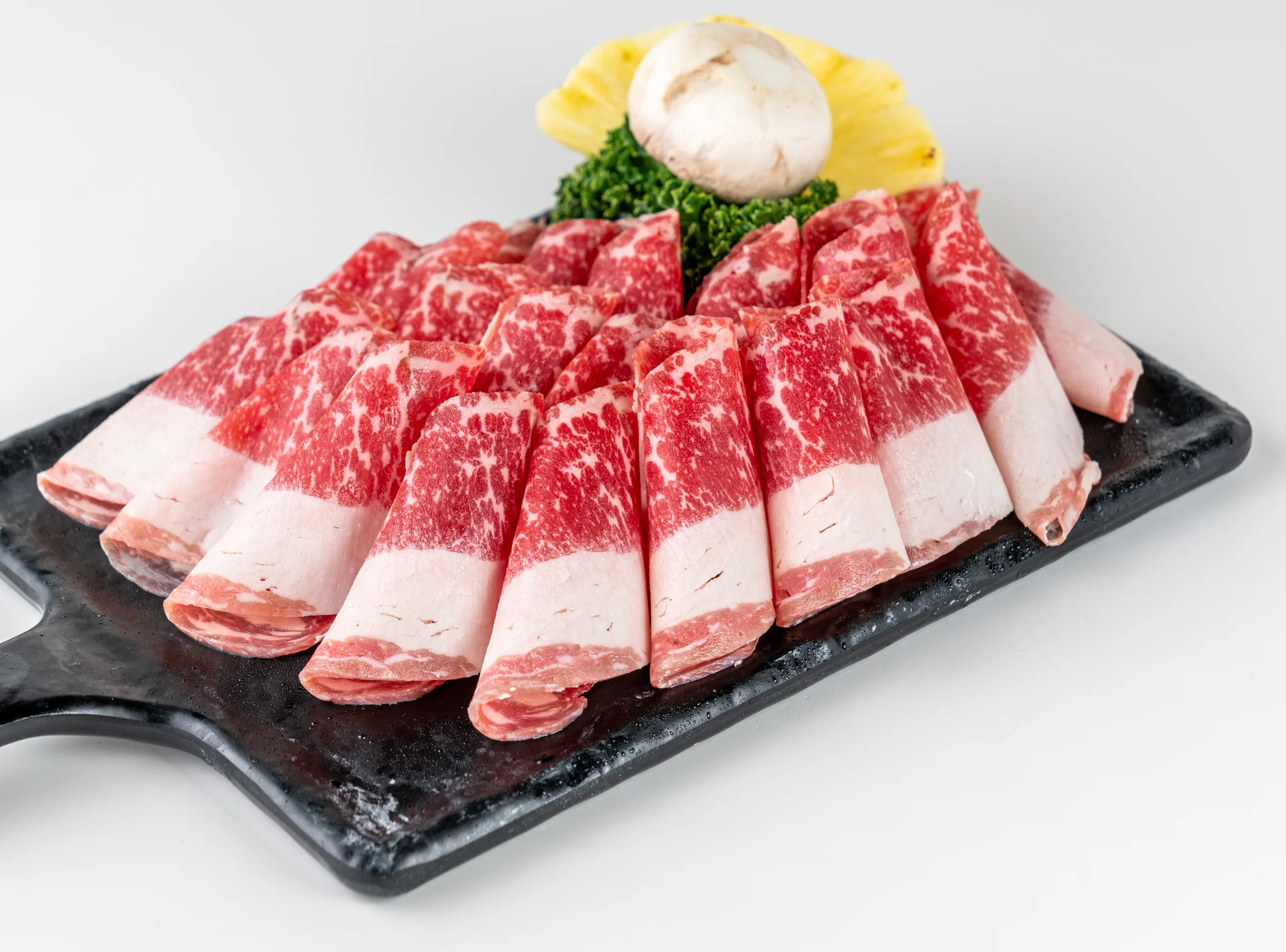 Sliced marbled beef for Korean BBQ on a black platter